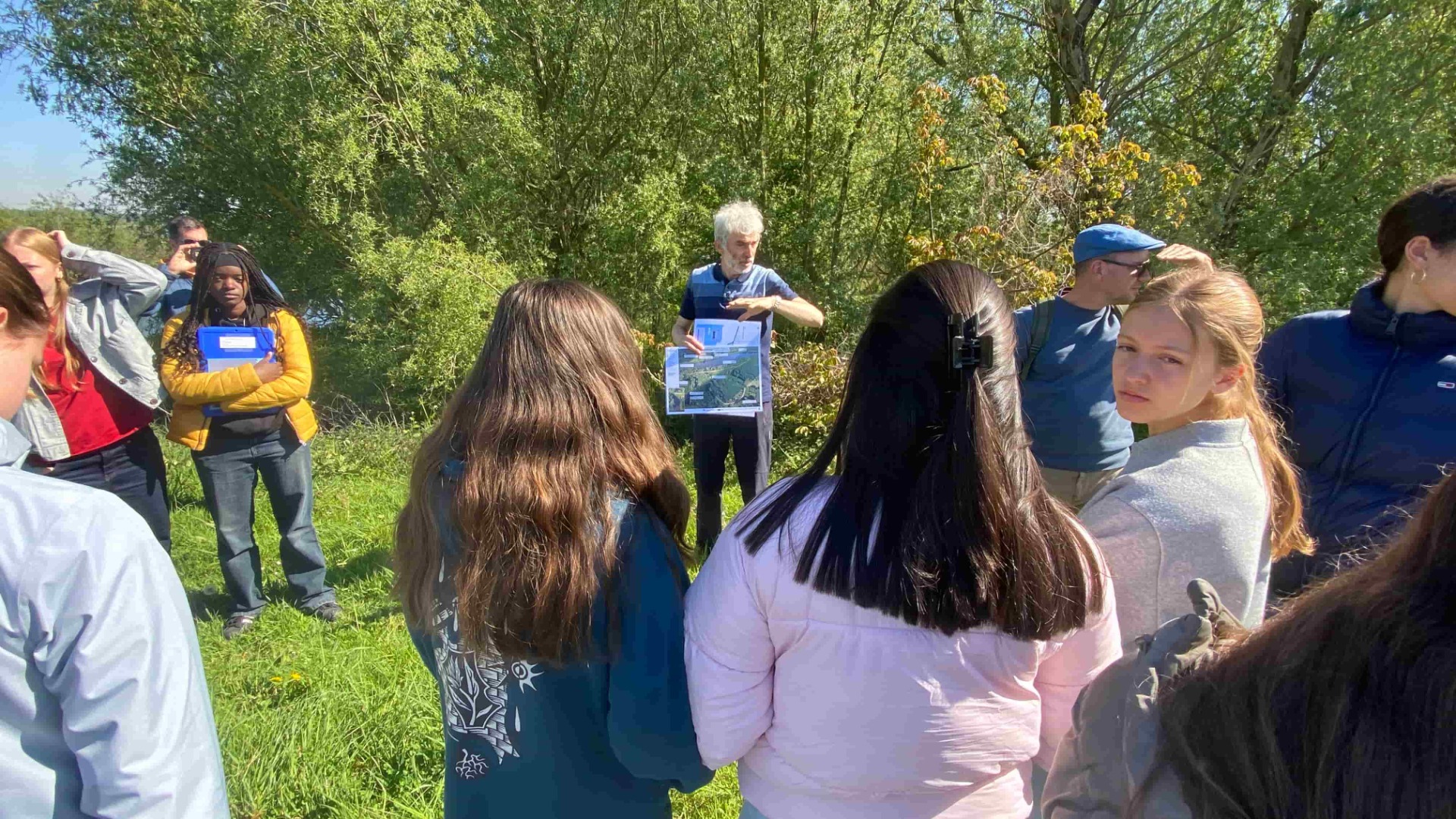 Klimaatgids geeft uitleg aan groep van leerlingen secundair onderwijs aan de Schelde